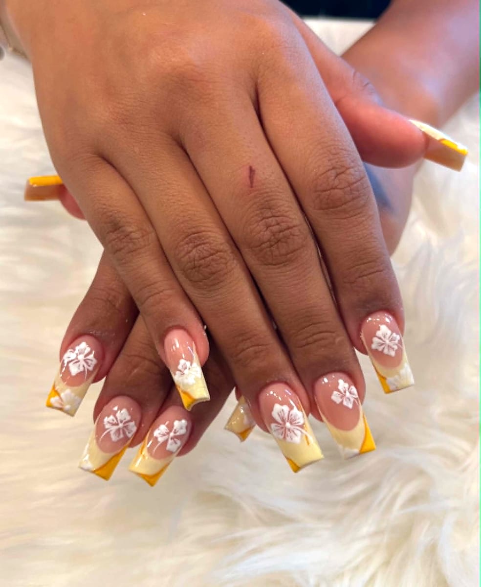 Yellow ombré French tips with white hibiscus art on long coffin nails