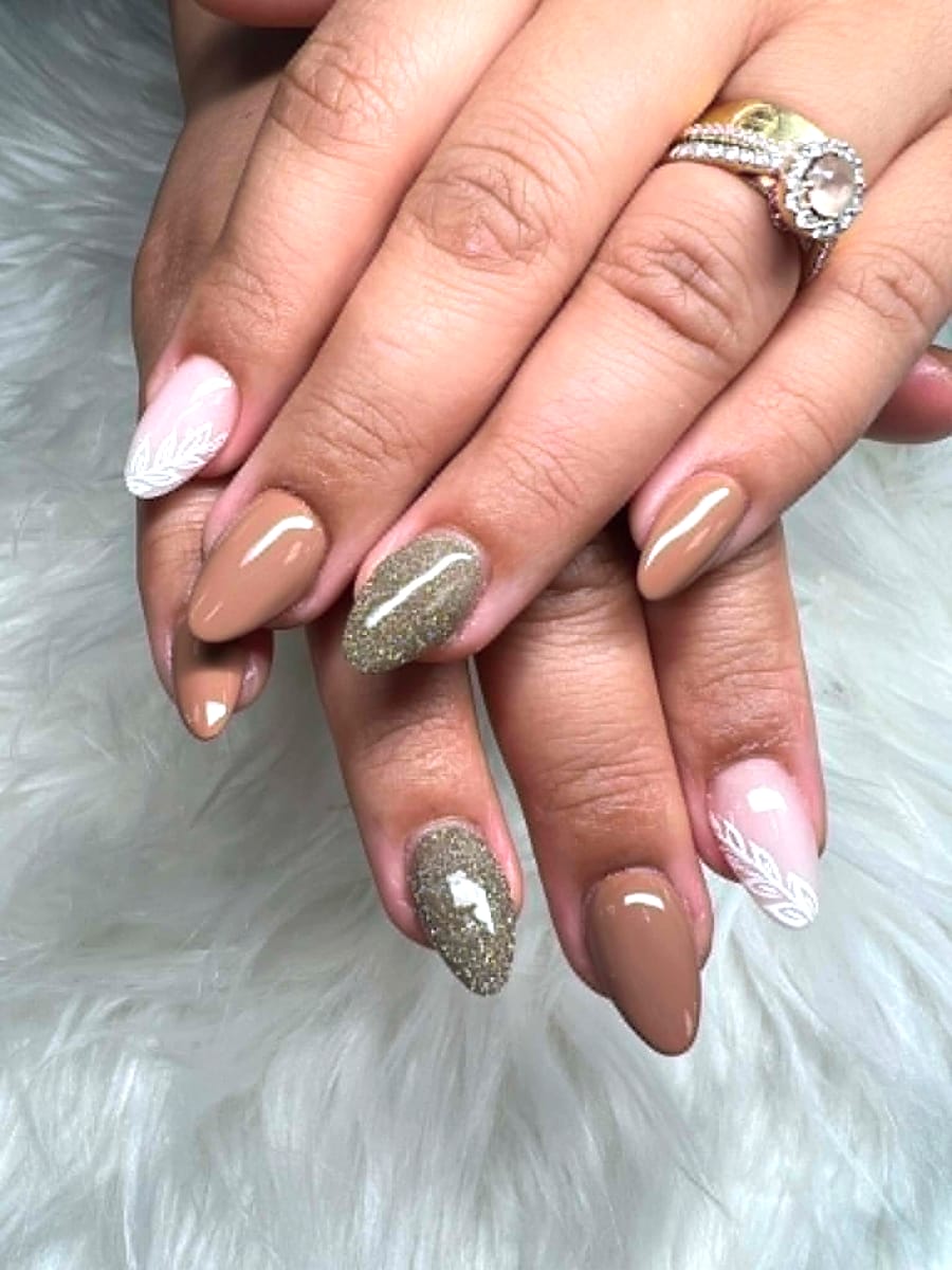 Nude almond manicure with caviar bead accent and white leaf detail